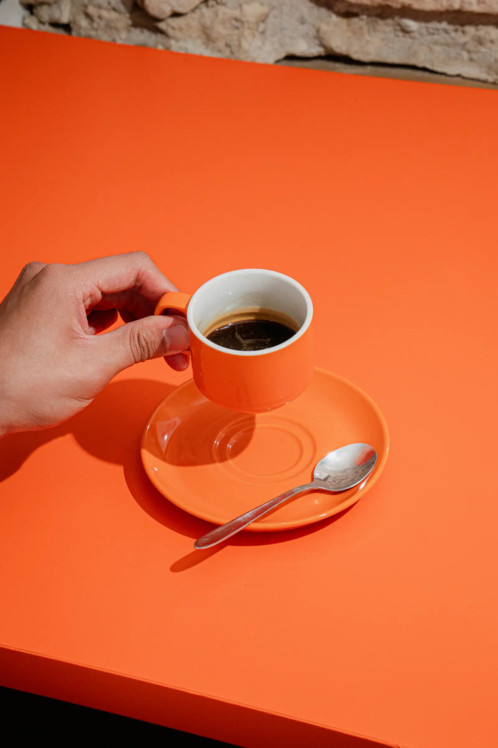 Espresso servi dans une tasse orange sur une table orange, coffee shop italien Aroma Caffè